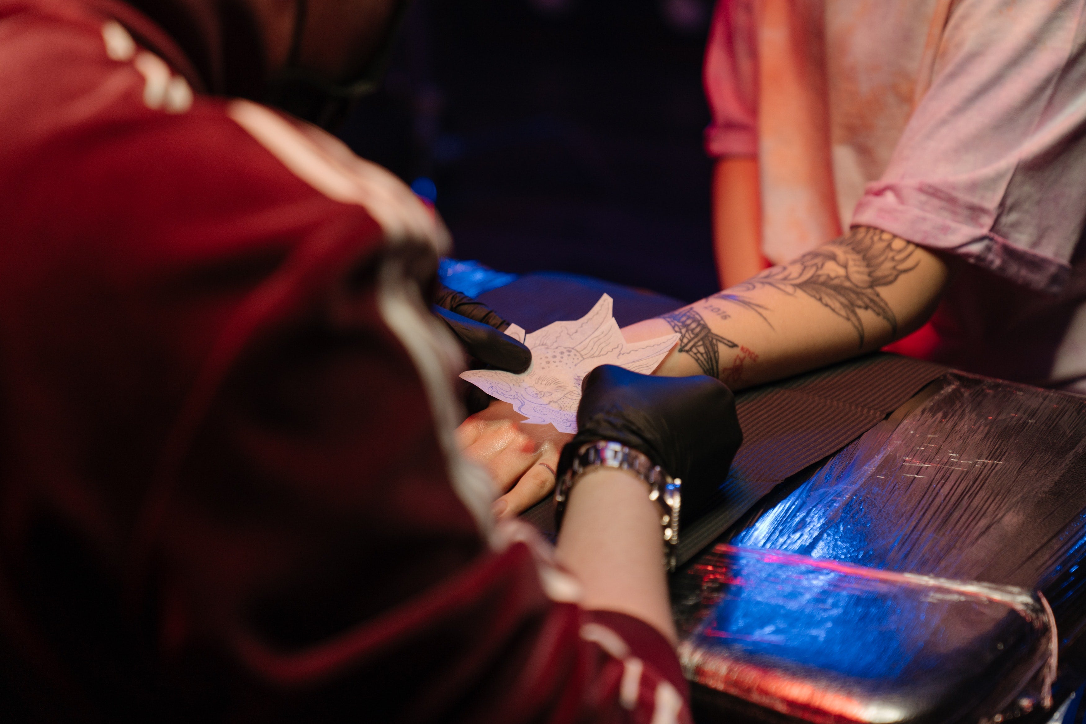 tattoo artist putting stencil on client